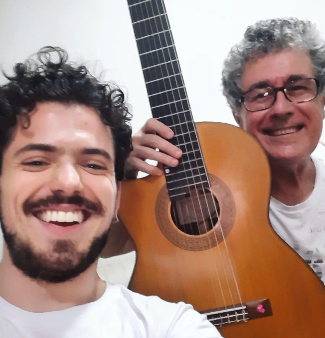 Igor Lazier and Cláudio Menandro beside a guitar