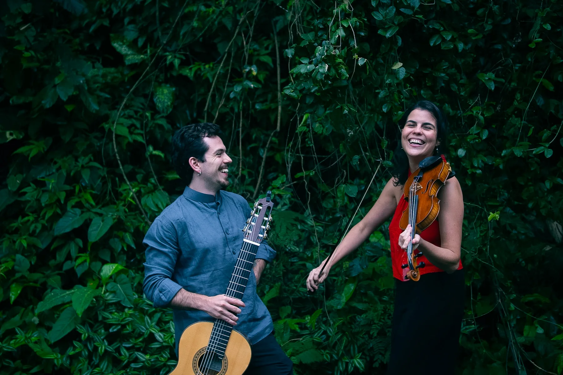 Igor Lazier with the 7-string guitar and Júlia Bomfim with the violin among greenery